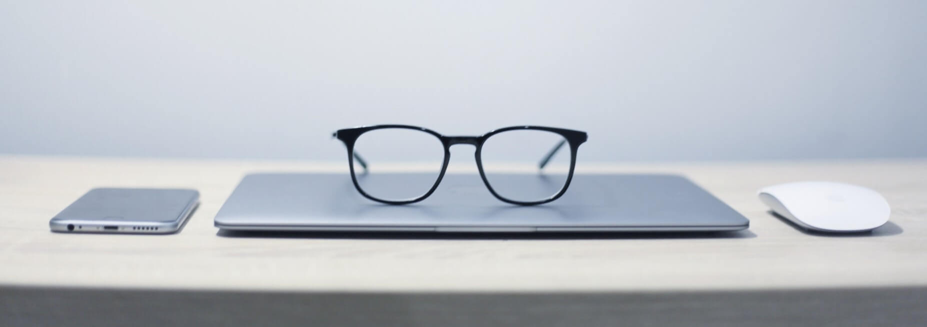 pair of glasses resting on a mac laptop