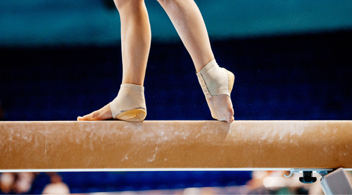 Gymnast feet on wooden beam