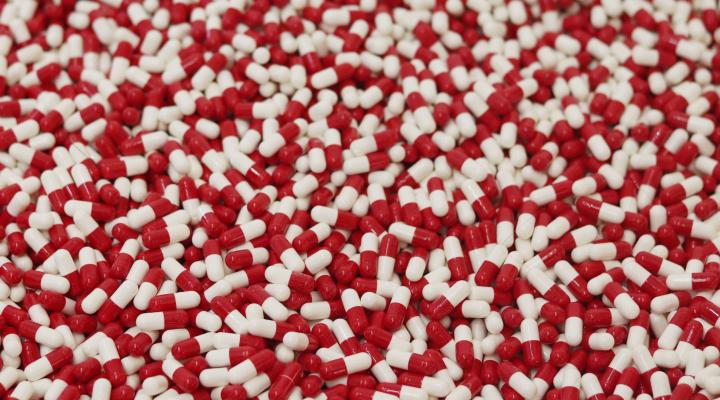red and white medicine capsules - Photo by analuisa gamboa on Unsplash