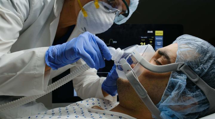 A doctor treating a patient on a ventilator